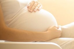 Femme enceinte caressant son ventre après un traitement de fertilité par insémination artificielle